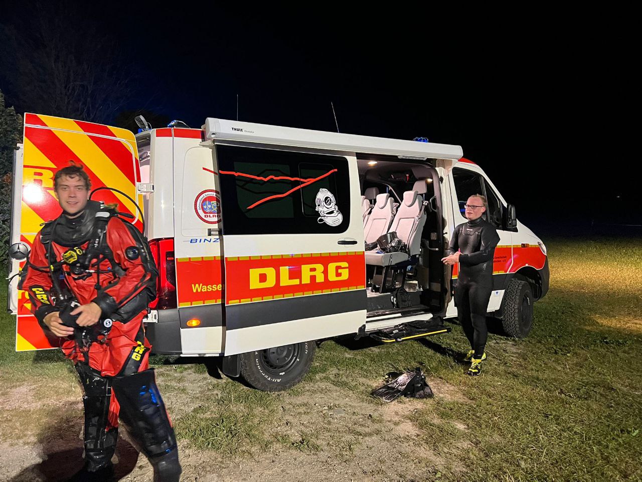Taucher am ausrüsten am Fahrzeug in Dunkelheit